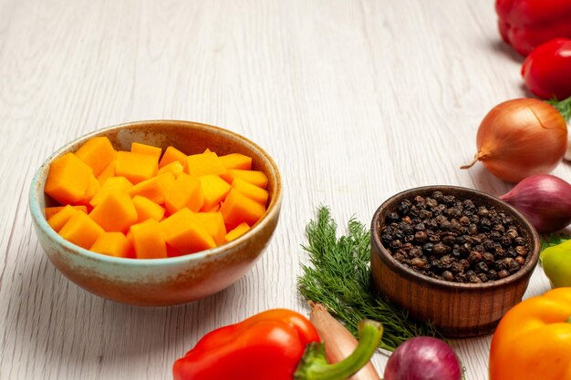 Vista frontal de verduras frescas con verduras en la dieta de salud madura de ensalada de escritorio blanco claro