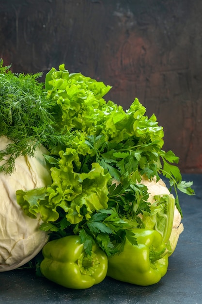 Vista frontal verduras repollo perejil pimientos lechuga eneldo coliflor sobre superficie oscura