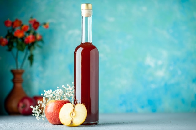Vista frontal de vinagre de manzana roja sobre fondo azul alimentos frutas alcohol vino jugo de color amargo