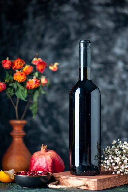 Vista frontal del vino de granada en la pared oscura beber alcohol de frutas vino de jugo de barra de color amargo