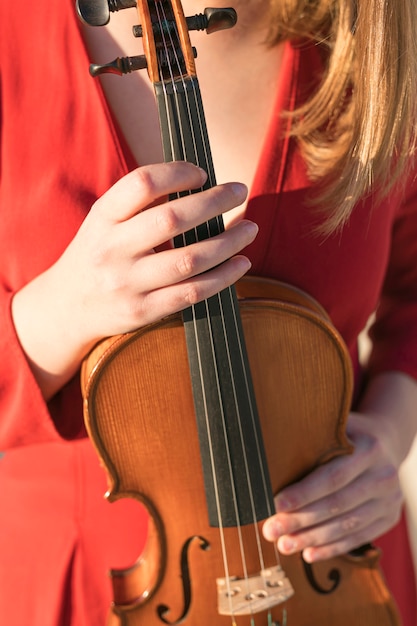 Vista frontal del violín sostenido por una mujer