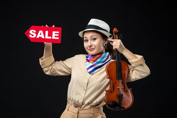 Foto gratuito vista frontal violinista sosteniendo violín y venta escribiendo en una pared oscura melodía música emoción concierto actuación mujer compras jugar