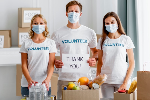 Vista frontal de los voluntarios agradeciendo su donación para el día de la comida.