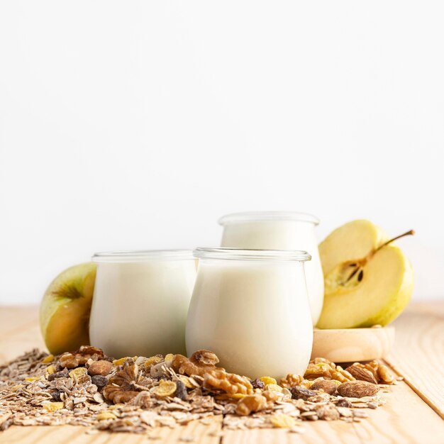 Vista frontal de yogur natural en frascos con avena y frutas