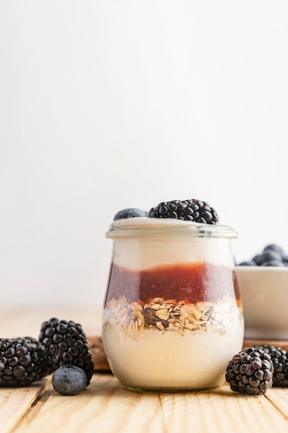 Vista frontal de yogurt con frutas del bosque, mermelada y avena