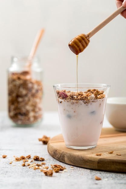 Vista frontal de yogurt con granola y miel