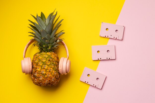 Vista de fruta de piña con cintas de casete y auriculares.