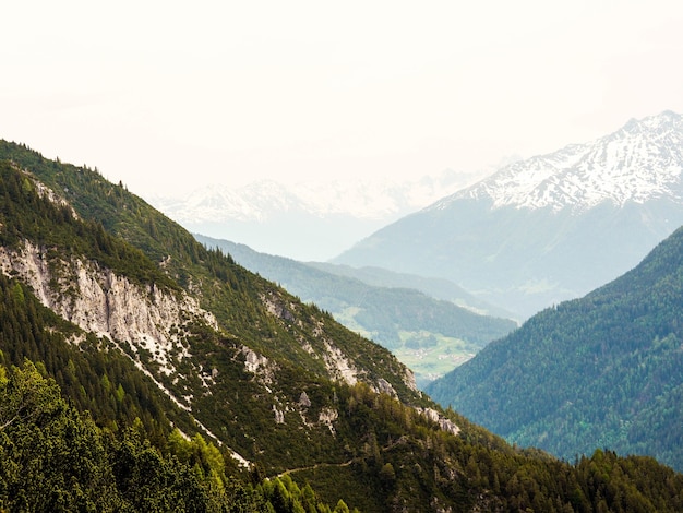 Foto gratuita vista de las grandes montañas alpinas en un día brumoso