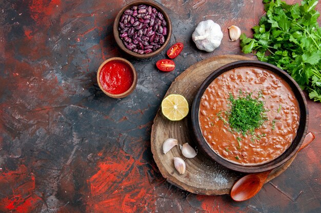 Vista horizontal del clásico jabón de tomate frijoles cuchara de ajo botella de aceite salsa de tomate y mayonesa de limón