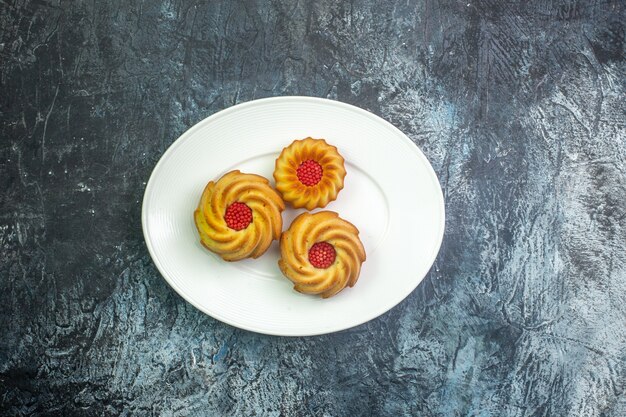 Vista horizontal de deliciosas galletas en un plato blanco sobre una superficie oscura