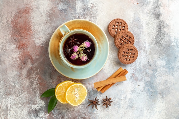 Vista horizontal de galletas de té de hierbas y rodajas de limón limón canela en mesa blanca