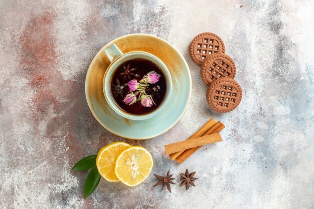 Vista horizontal de galletas de té de hierbas y rodajas de limón limón canela en mesa blanca