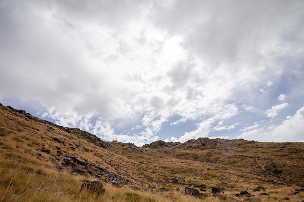 Foto gratuita la vista horizontal de una ladera seca bajo un cielo nublado en sierra nevada, españa