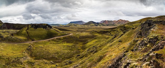 La vista horizontal de las montañas y los campos de la región de las Tierras Altas, Islandia bajo el cielo azul