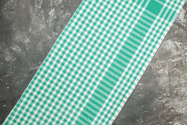 Vista horizontal de la toalla de rayas verdes sobre mesa gris