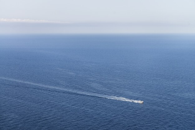 Vista idílica de un barco en un océano azul con un horizonte despejado, perfecto para papel tapiz