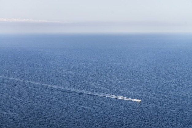 Vista idílica de un barco en un océano azul con un horizonte despejado, perfecto para papel tapiz