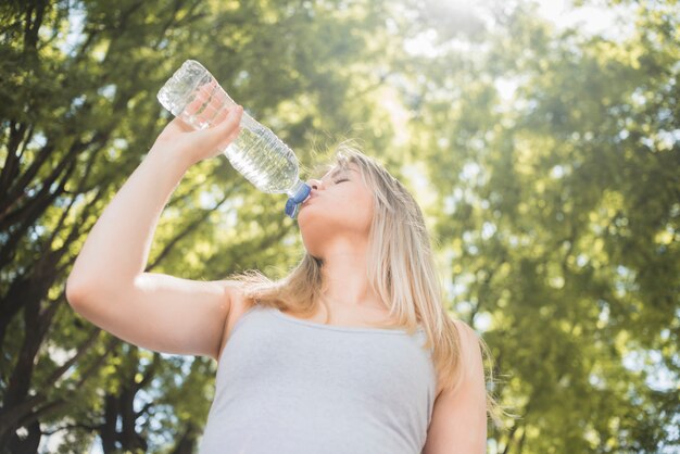 Vista inferior chica deportista bebiendo agua