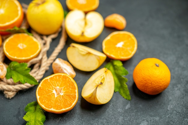 Vista inferior cortadas naranjas y manzanas cortadas naranja en la oscuridad