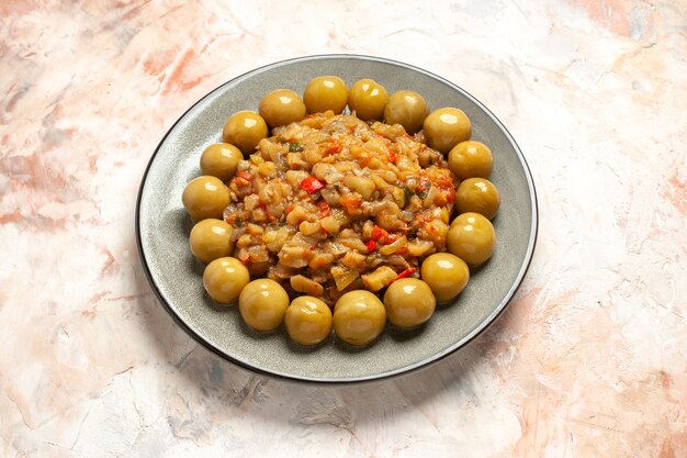 Foto gratuita vista inferior ensalada de berenjena asada y ciruelas en escabeche en la placa en la mesa desnuda