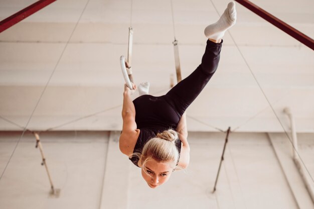 Vista inferior joven formación en anillos de gimnasia