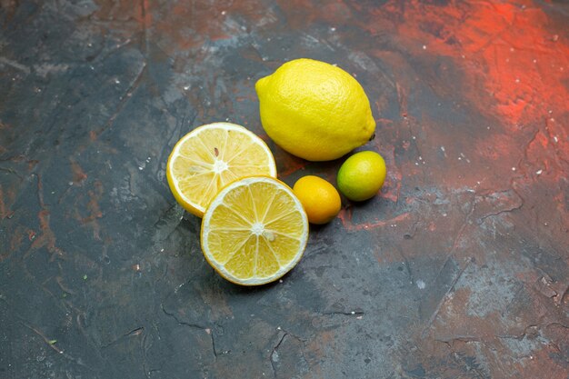Vista inferior limones frescos cortados limones cumcuat en el espacio libre de tierra de color rojo oscuro