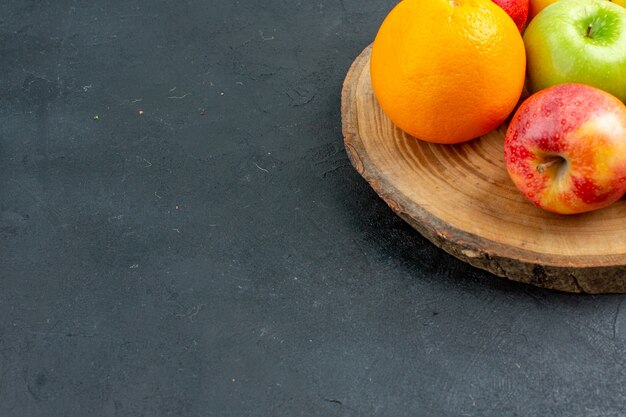 Vista inferior manzanas naranjas limón sobre tablero de madera en el espacio de copia de superficie oscura