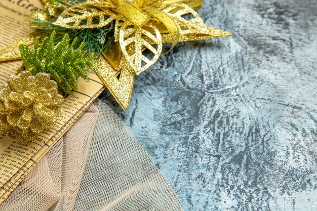 Vista inferior de Navidad adornos colgantes en mantón de periódico beige sobre fondo oscuro lugar libre