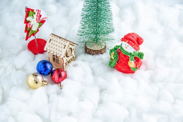 Vista inferior pequeños juguetes de bolas de casa de madera de árbol de Navidad sobre superficie blanca aislada