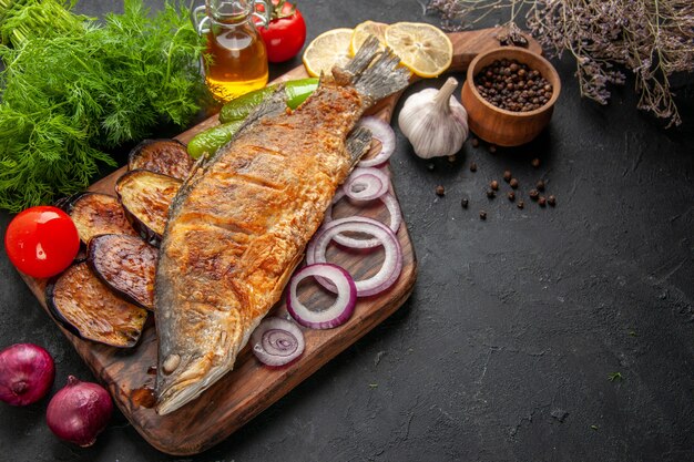 Vista inferior de pescado freír berenjenas fritas cebolla en tablero de madera para servir pimienta negra botella de aceite eneldo sobre fondo oscuro