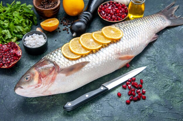 Vista inferior de pescado fresco con rodajas de limón cuchillo en la mesa de la cocina