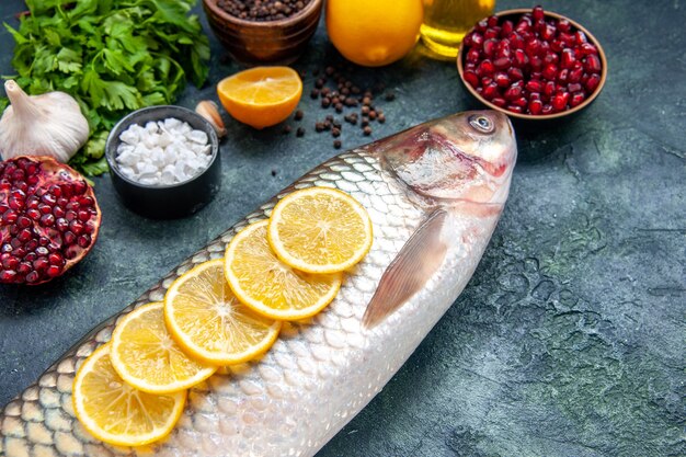 Vista inferior de pescado fresco con rodajas de limón en la mesa de la cocina