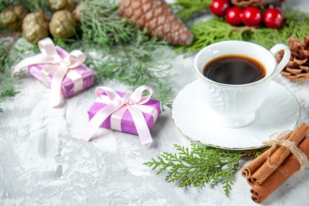 Vista inferior ramas de pino pequeños regalos juguetes de árbol de navidad en gris