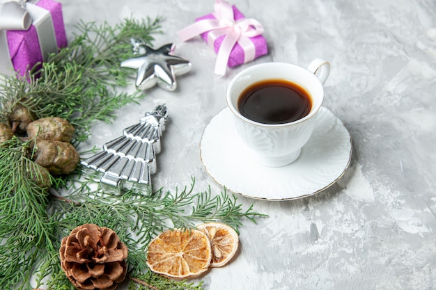 Vista inferior ramas de pino taza de té rodajas de limón secas piñas pequeños obsequios en gris