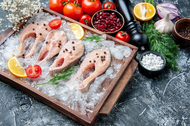 Vista inferior rebanadas de pescado crudo con hielo en tazones de madera con semillas de granada, sal marina negra