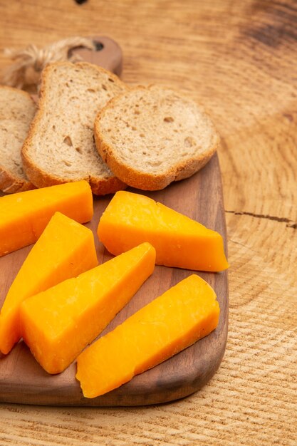 Vista inferior rebanadas de queso rebanadas de pan sobre una tabla de cortar en la mesa