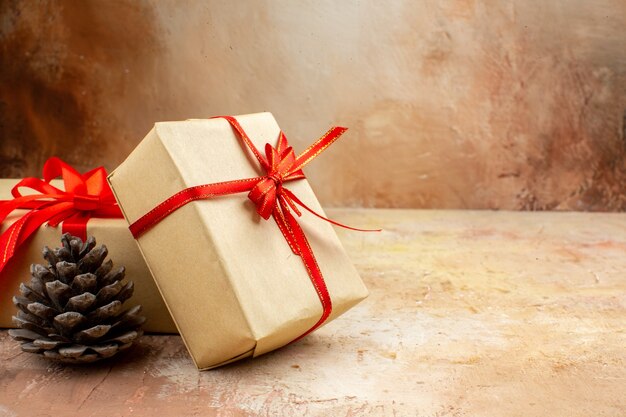 Vista inferior de los regalos de Navidad en la cinta de papel marrón, el árbol de Navidad de juguete en el periódico en la oscuridad.