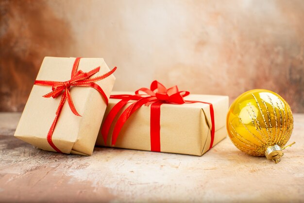 Vista inferior de los regalos de Navidad en la cinta de papel marrón, el árbol de Navidad de juguete en el periódico en la oscuridad.