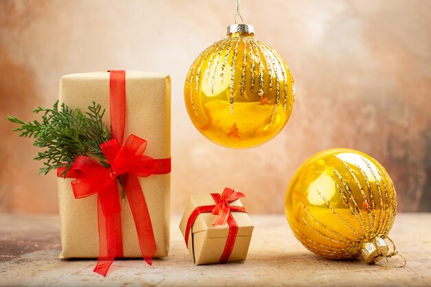 Vista inferior de los regalos de Navidad en la cinta de papel marrón, el árbol de Navidad de juguete en el periódico en la oscuridad.