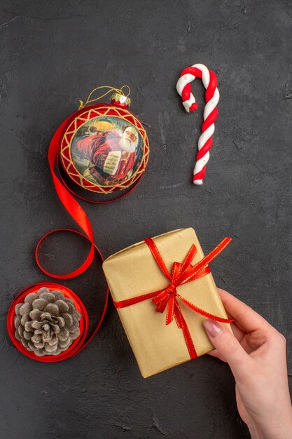 Vista inferior de regalos de Navidad en cinta de papel marrón juguete de árbol de Navidad en periódico sobre fondo oscuro