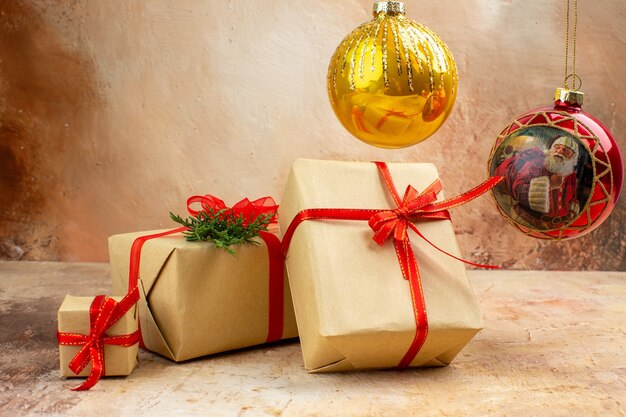 Vista inferior de regalos de Navidad en cinta de papel marrón juguete de árbol de Navidad en periódico sobre fondo oscuro