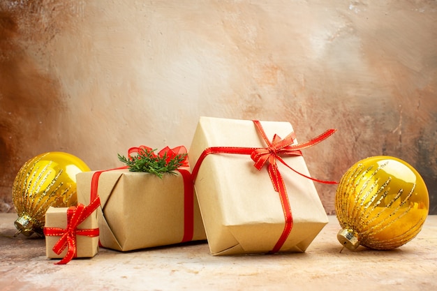 Vista inferior de regalos de Navidad en cinta de papel marrón juguete de árbol de Navidad en periódico sobre fondo oscuro