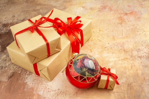 Vista inferior de regalos de Navidad en cinta de papel marrón juguete de árbol de Navidad en periódico sobre fondo oscuro