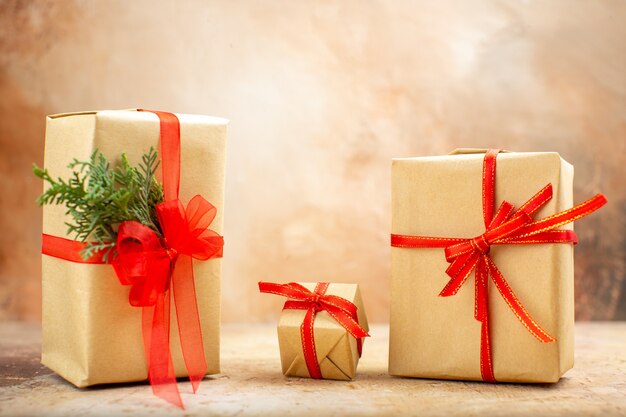 Vista inferior de los regalos de Navidad en la cinta de papel marrón juguetes del árbol de Navidad en el periódico sobre fondo beige