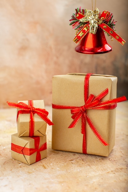 Vista inferior de los regalos de Navidad en la cinta de papel marrón juguetes del árbol de Navidad en el periódico sobre fondo beige