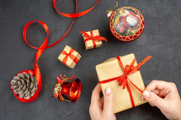 Vista inferior de los regalos de Navidad en la cinta de papel marrón juguetes del árbol de Navidad en el periódico sobre fondo beige