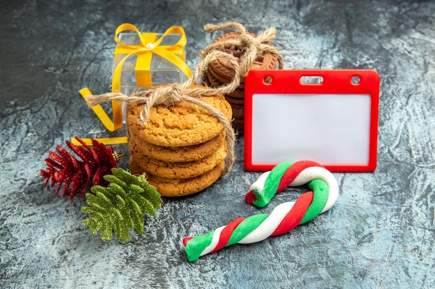 Vista inferior regalos de Navidad galletas atadas dulces de Navidad juguetes de árbol de Navidad sobre fondo gris