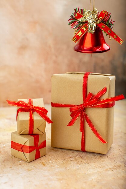 Vista inferior de regalos de Navidad en papel marrón juguetes de árbol de Navidad de cinta en periódico en beige