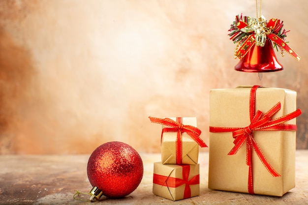 Vista inferior de regalos de Navidad en papel marrón juguetes de árbol de Navidad de cinta en periódico en beige