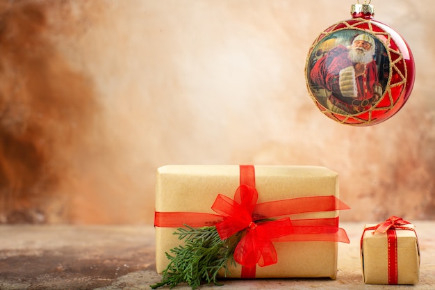 Vista inferior de regalos de Navidad en papel marrón juguetes de árbol de Navidad de cinta en periódico en beige